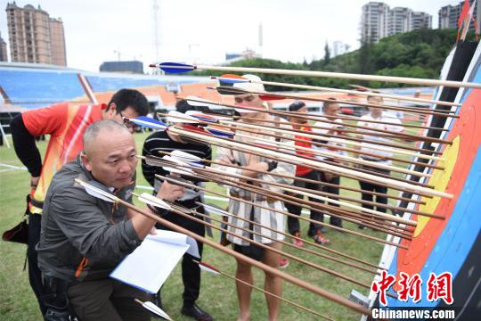 经过一番角逐，箭靶上插满了箭，选手们正核对成绩。　陈龙山 摄